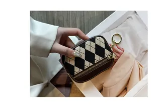 Nahaufnahme der Mini-Münztasche mit Rautenmuster und Goldreißverschluss