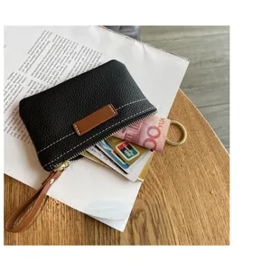 Vue détaillée d'un porte-monnaie slim en cuir noir avec cartes et espèces sur une table