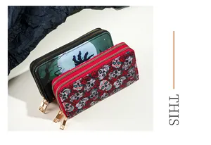 High-detail view of two women's long wallets featuring Halloween and sugar skull print patterns.