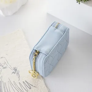 Light blue portable diamond quilted cosmetic bag with an elegant gold zipper puller
