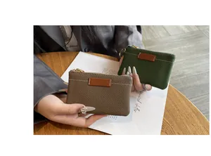 Vue détaillée de la texture des mini porte-monnaie en cuir en vert et taupe.