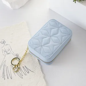 Portable light blue quilted cosmetic bag with gold keychain for small makeup storage