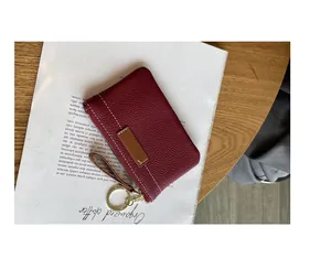 Vue détaillée d'un porte-monnaie en cuir grainé bordeaux avec un porte-clés doré élégant