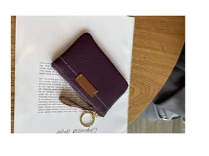 Vue détaillée d'un porte-monnaie slim en cuir violet avec anneau porte-clés sur table