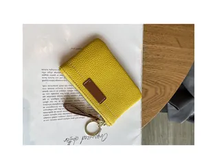 Vue détaillée d'un porte-monnaie en cuir grainé jaune avec anneau et dragonne