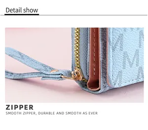 Macro detail of high-quality gold zipper on a blue trifold wallet with M-pattern