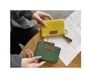 Gros plan sur des porte-monnaie en cuir jaune et vert avec porte-clés
