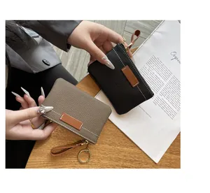 Détail de mini porte-monnaie en cuir martelé noir et taupe avec porte-clés