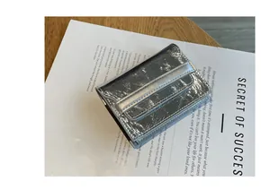 Detailed view of the shiny silver leather card holder with textured metallic finish.