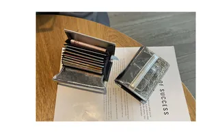 Macro view of silver leather card holder showing internal multi-slot bellows structure.