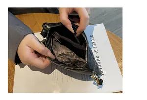 Vue intérieure détaillée d'une pochette en cuir gaufré noir avec plusieurs compartiments