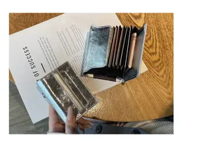 Detailed view of silver leather card holder showing multi-slot accordion style interior