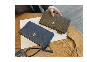 Détails de pochettes élégantes en cuir gaufré avec motif floral en gris et marron