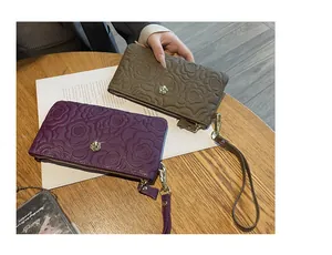 Vue détaillée du motif de rose gaufré sur la pochette pour femme en cuir véritable
