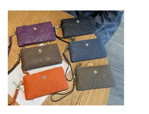 Vue détaillée de pochettes en cuir gaufré avec motif rose en plusieurs couleurs