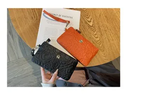 Gros plan de portefeuilles en cuir gaufré de qualité supérieure en noir et orange vif