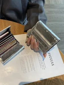 Silver metallic genuine leather card holder with multi-slot design on a magazine