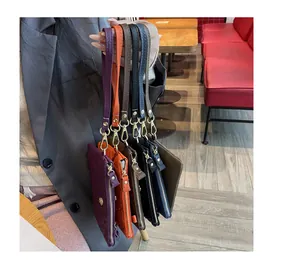 Variété de pochettes en cuir véritable gaufré pour femmes aux couleurs élégantes.