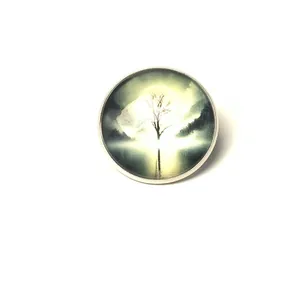 Close-up of a vintage tree landscape time gem brooch with silver metal bezel.