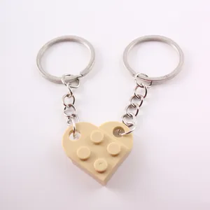 Close-up detail of interlocking heart-shaped building block keychain in beige finish