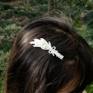 Detail shot of a silver rhinestone flower bouquet hair clip worn on dark hair.