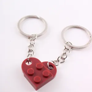 Macro detail of a red heart-shaped brick keychain featuring two interlocking pieces.
