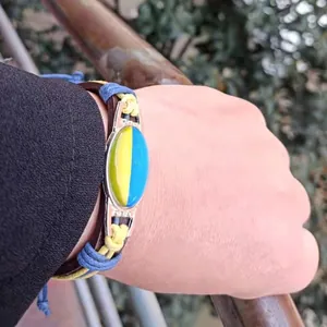 Close-up of a handmade woven leather bracelet featuring a yellow and blue time gem