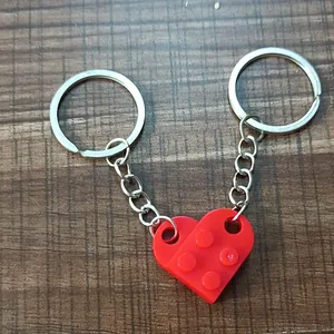 Macro view of red heart-shaped building block keychain on a brown wooden surface