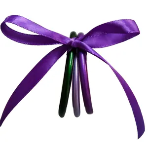 Set aus drei bunten Jelly Bangles in Grün und Lila, mit Seidenband gebunden.