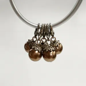Detailed view of bronze pearl pendants with vintage silver flower caps and lobster clasps