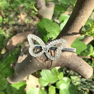 Close-up of a sparkling silver rhinestone butterfly hair clip on a natural tree branch