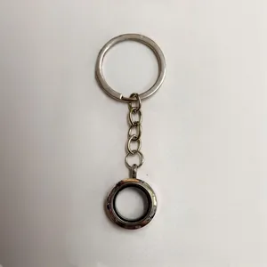 Detailopname van een zilveren ronde zwevende medaillon sleutelhanger met magneet