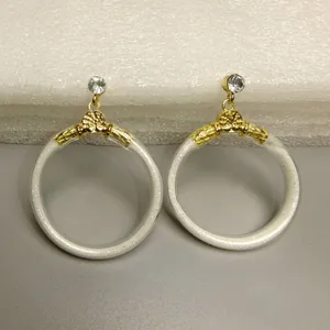Gedetailleerde macro-opname van gouden oorringen met glitters en heldere strass