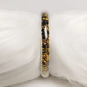 Vista detallada de brazalete jelly de PVC transparente de 9mm con cristales dorados y negros