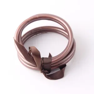 Dettaglio di braccialetti jonc bouddhiste marroni in silicone flessibile con un nastro.