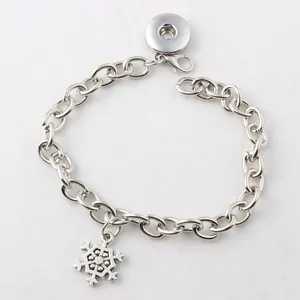Detailansicht eines silbernen Armbands mit Schneeflocken-Anhänger und Druckknopfbasis