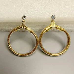 Gedetailleerd aanzicht van grote goudkleurige glitter gevulde transparante jelly ringen.