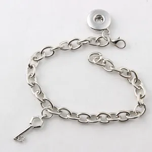 Details eines DIY-Druckknopf-Armbands mit silbernem Schlüsselanhänger und Gliederkette.