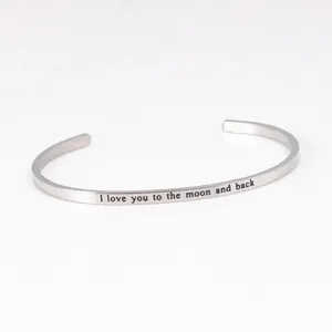 Close-up of stainless steel cuff bracelet with I love you to the moon and back engraving