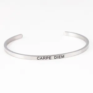 Detailed view of silver stainless steel open cuff bracelet with Carpe Diem engraving