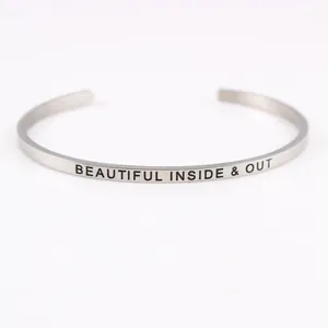 Macro view of silver stainless steel cuff bracelet with 'Beautiful Inside & Out' engraving