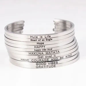 Stack of minimalist stainless steel engraved cuff bracelets with inspirational quotes