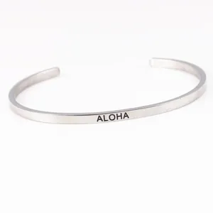 Détail d'un bracelet jonc minimaliste en acier inoxydable argenté avec gravure ALOHA