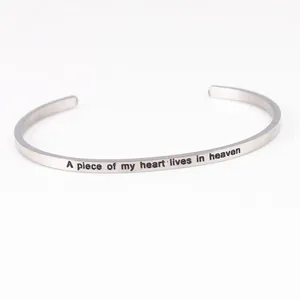 Gros plan d'un bracelet jonc en acier inoxydable avec détail de gravure sentimentale