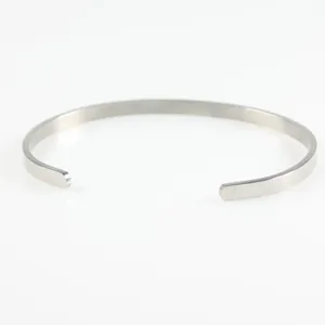 Detail eines minimalistischen silbernen Edelstahl-Armreifs mit mattem Finish und Öffnung.