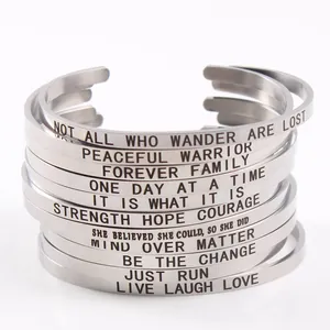 Detailansicht mehrerer silberner Edelstahl-Mantra-Armbänder mit inspirierenden Zitaten.