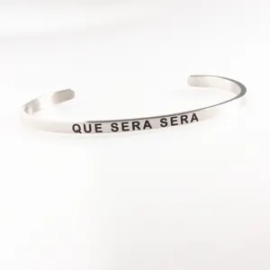 Polished silver stainless steel open cuff mantra bracelet with Que Sera Sera engraving