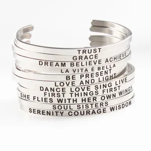 Stack of stainless steel cuff bracelets featuring various inspirational engraved quotes