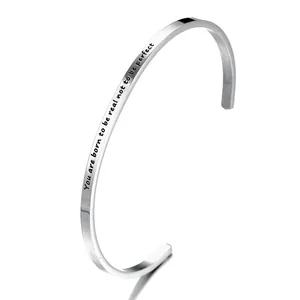 Detailed close-up of a silver stainless steel open bangle with an engraved quote