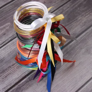 Gros plan de bracelets joncs en silicone pailleté avec rubans de satin colorés